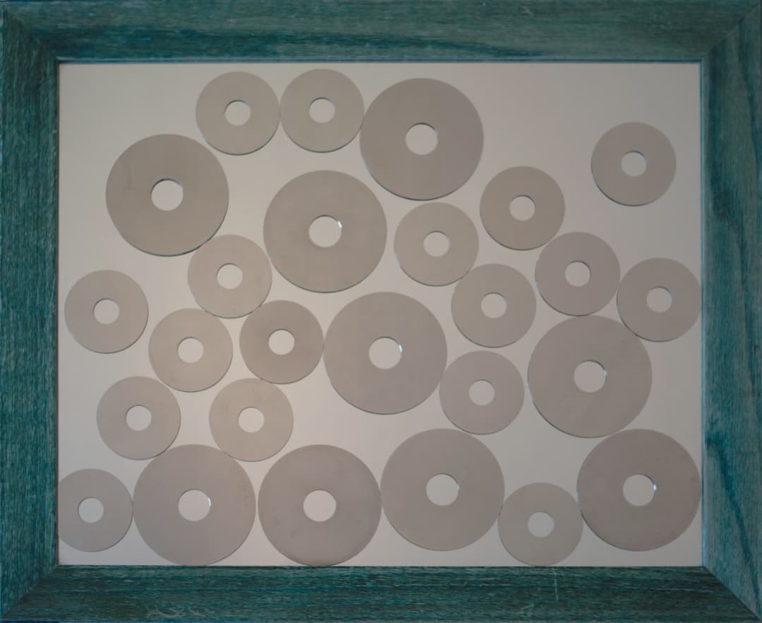 A sculpture titled: Image. The sculpture is a mirror with reflective disc hard drive platters affixed to it.